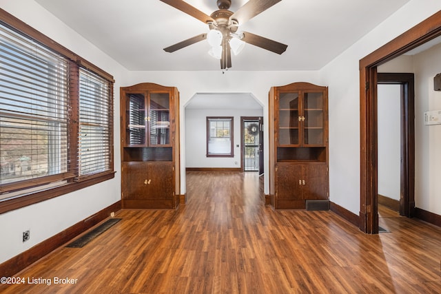 unfurnished living room with ceiling fan and dark hardwood / wood-style flooring