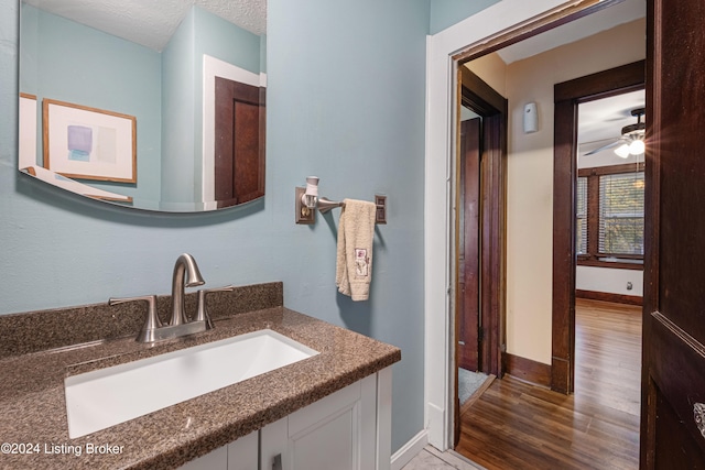 bathroom with a textured ceiling, ceiling fan, and vanity