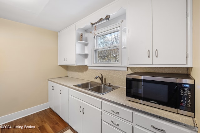 kitchen with sink, dark hardwood / wood-style flooring, and white cabinetry