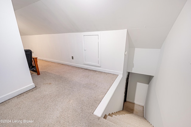 bonus room featuring vaulted ceiling and light carpet