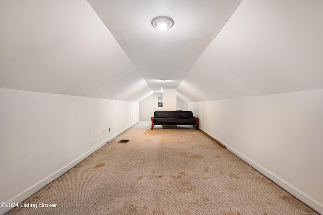 additional living space with light carpet and lofted ceiling