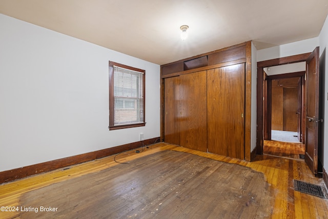 unfurnished bedroom featuring a closet and dark hardwood / wood-style floors