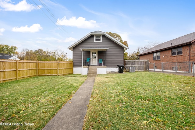 back of property featuring central AC and a lawn