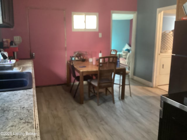 dining space featuring light hardwood / wood-style floors and sink