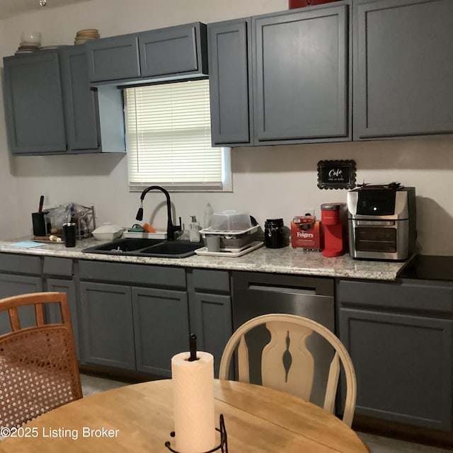 kitchen with light countertops, a sink, and gray cabinets