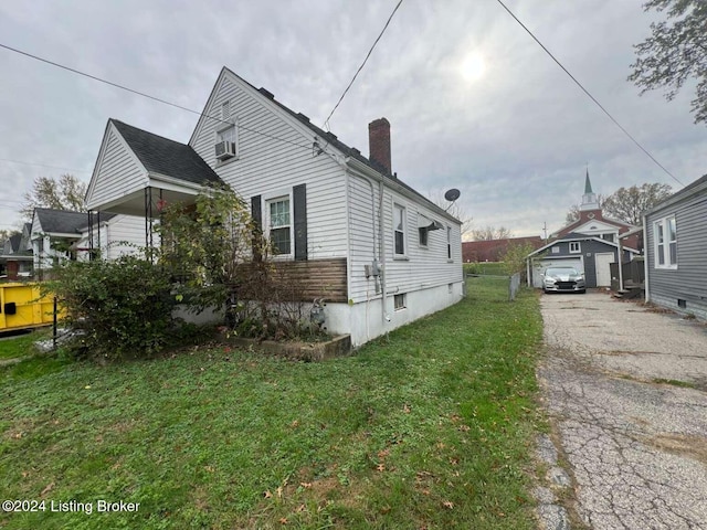 view of home's exterior with an outbuilding, a yard, and a garage