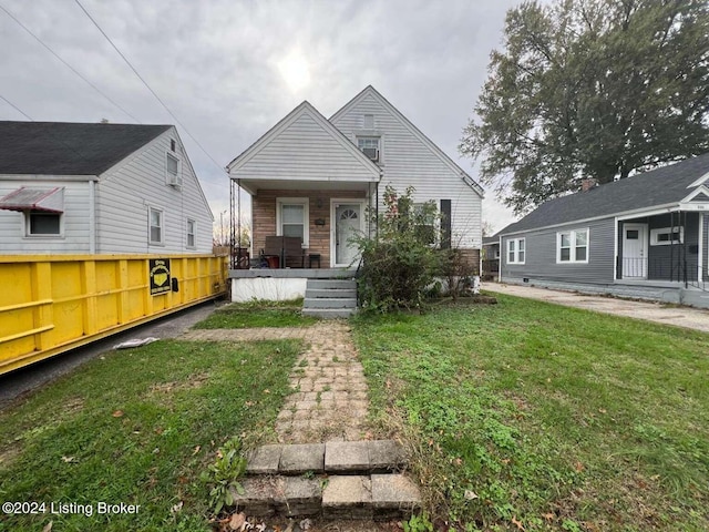 bungalow-style home with covered porch and a front lawn