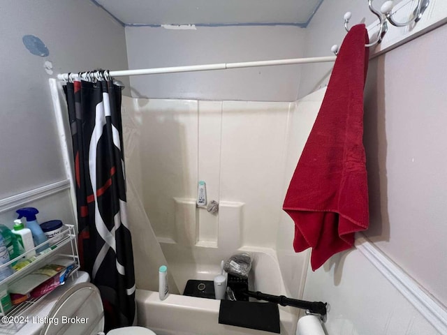 bathroom featuring toilet and shower / tub combo with curtain