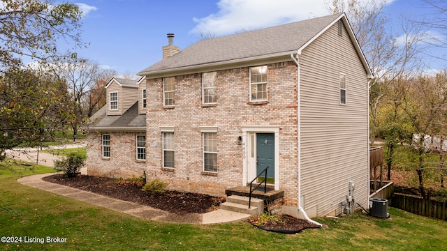 back of house featuring central AC and a yard