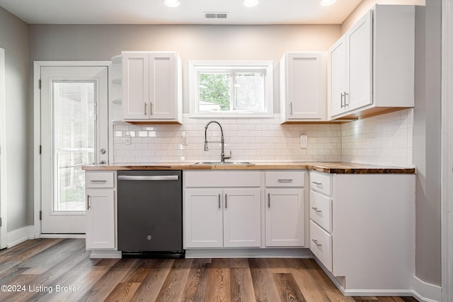 kitchen with white cabinetry, sink, wooden counters, stainless steel dishwasher, and hardwood / wood-style flooring