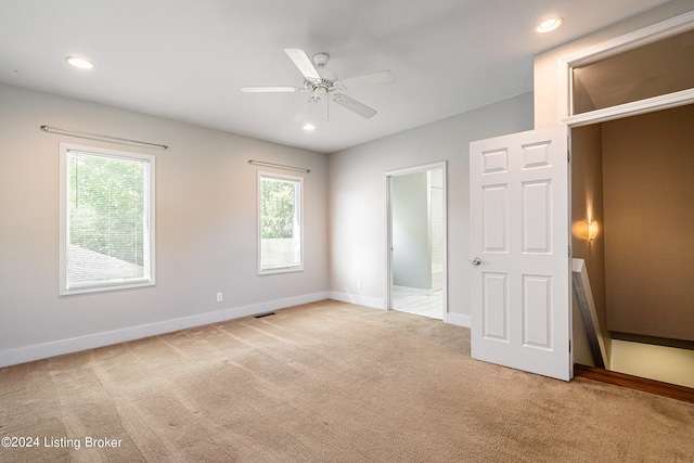 unfurnished bedroom featuring light carpet and ceiling fan