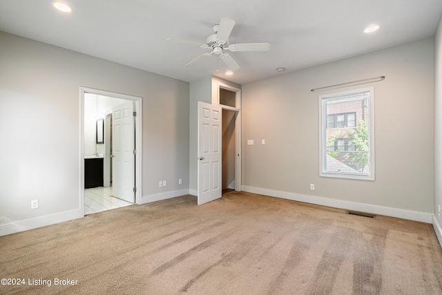 unfurnished bedroom featuring ensuite bathroom, ceiling fan, and light colored carpet