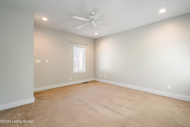 carpeted spare room with ceiling fan