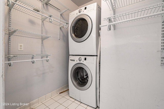 washroom with light tile patterned floors and stacked washer / dryer