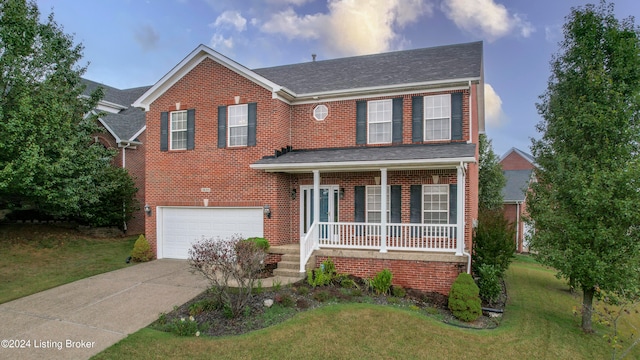 view of front of home with a porch, a garage, and a front lawn