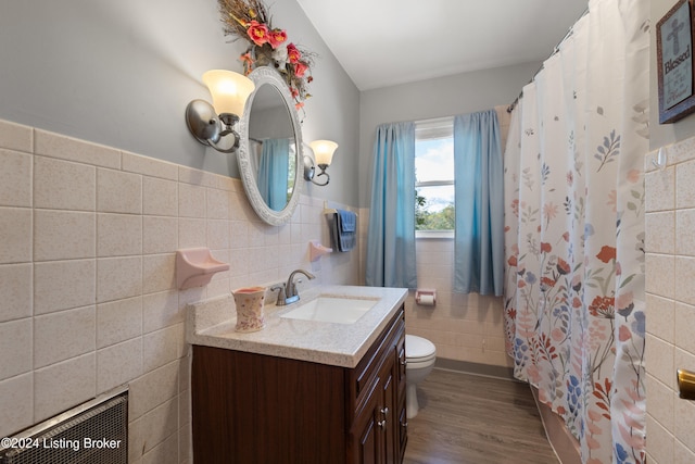 bathroom featuring hardwood / wood-style flooring, vanity, toilet, and tile walls