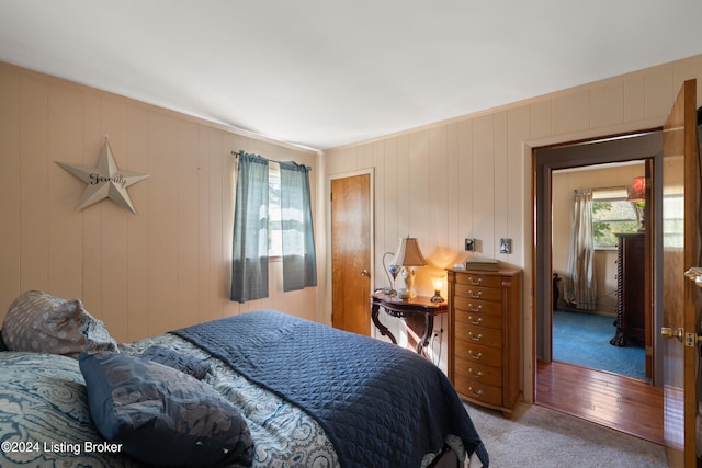 bedroom with wooden walls and hardwood / wood-style flooring