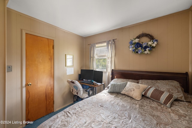 bedroom featuring wood walls and carpet floors