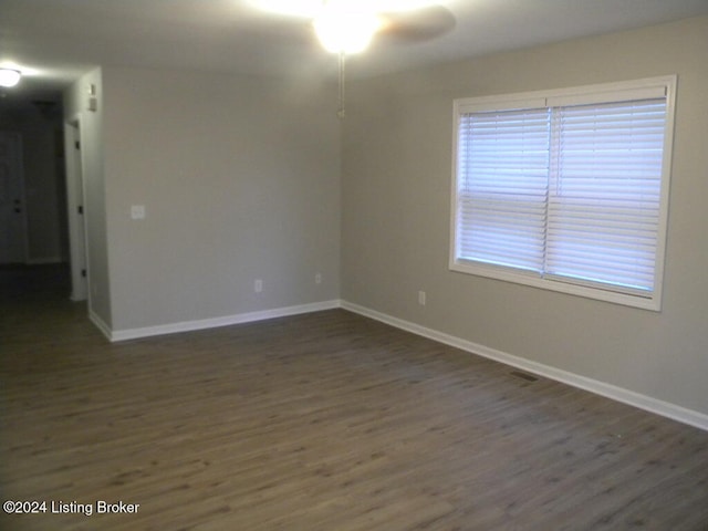 spare room featuring dark hardwood / wood-style flooring and ceiling fan