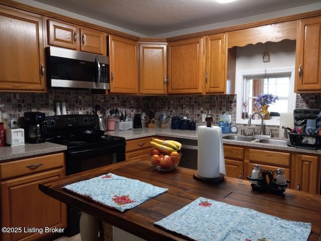 kitchen with tasteful backsplash, stainless steel microwave, a sink, wood counters, and black / electric stove