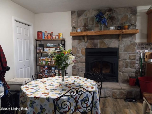 dining room with a fireplace and wood finished floors