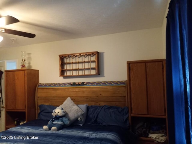 bedroom with a wainscoted wall, ceiling fan, and wooden walls