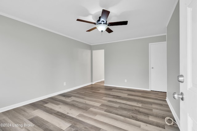 empty room featuring ceiling fan, light wood-type flooring, and ornamental molding