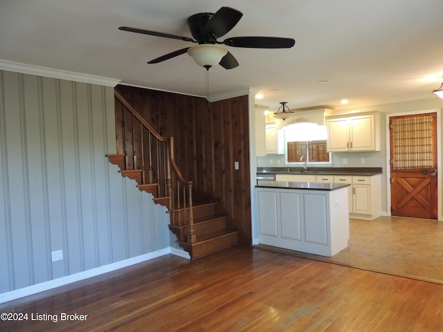 kitchen with ceiling fan, sink, crown molding, light hardwood / wood-style floors, and white cabinets