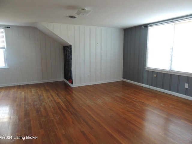 bonus room featuring wooden walls and dark hardwood / wood-style flooring