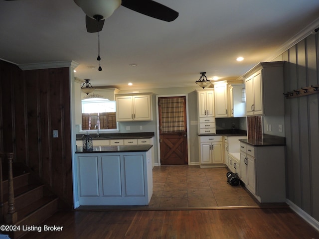 kitchen with white cabinetry, dark hardwood / wood-style flooring, ornamental molding, and sink