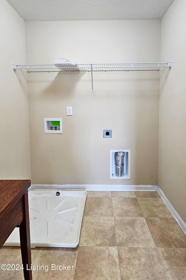 clothes washing area with hookup for an electric dryer, washer hookup, and a textured ceiling