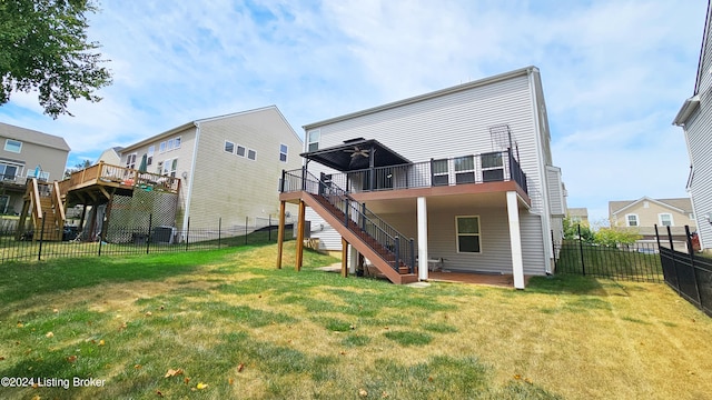 back of house featuring a lawn, a wooden deck, and cooling unit