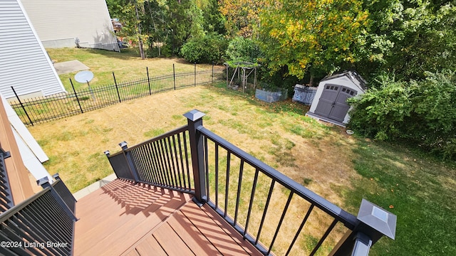 wooden terrace featuring a lawn and a storage unit