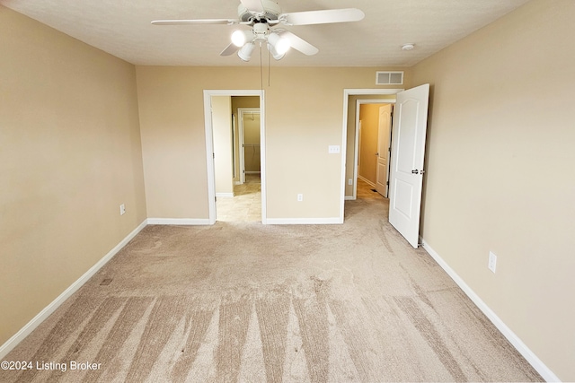 unfurnished bedroom with ceiling fan and light carpet