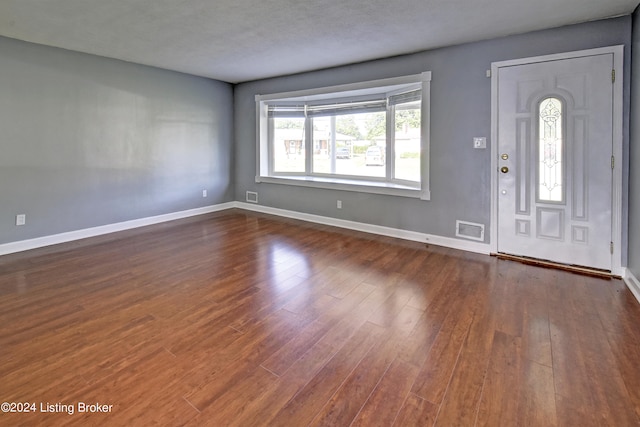 foyer with dark hardwood / wood-style floors and a textured ceiling