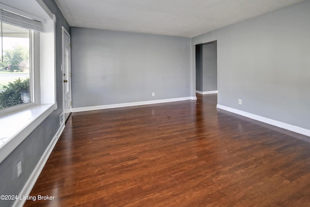 unfurnished room featuring dark wood-type flooring