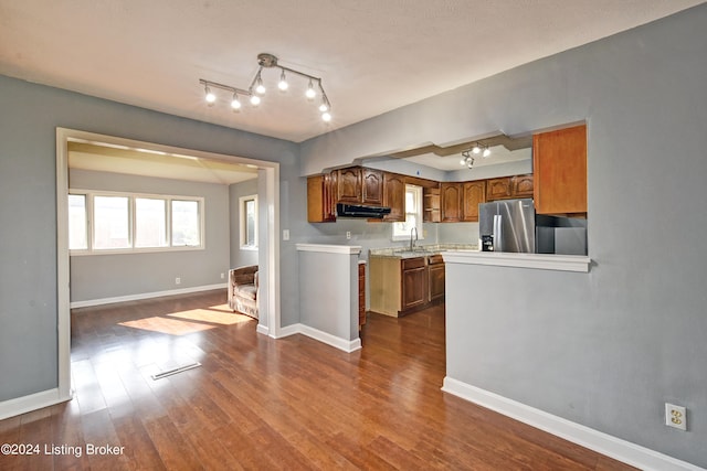 kitchen with stainless steel fridge, sink, wood-type flooring, and extractor fan