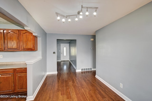 interior space featuring dark wood-type flooring and track lighting