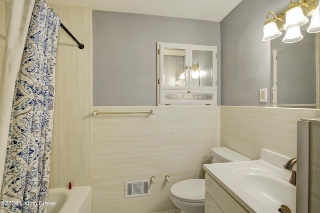 full bathroom with vanity, toilet, shower / bath combo with shower curtain, and tile walls