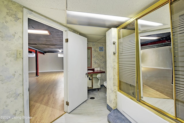 hallway featuring a paneled ceiling and light hardwood / wood-style flooring