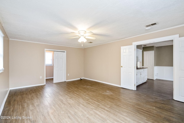 unfurnished room featuring hardwood / wood-style floors, ceiling fan, ornamental molding, and a textured ceiling