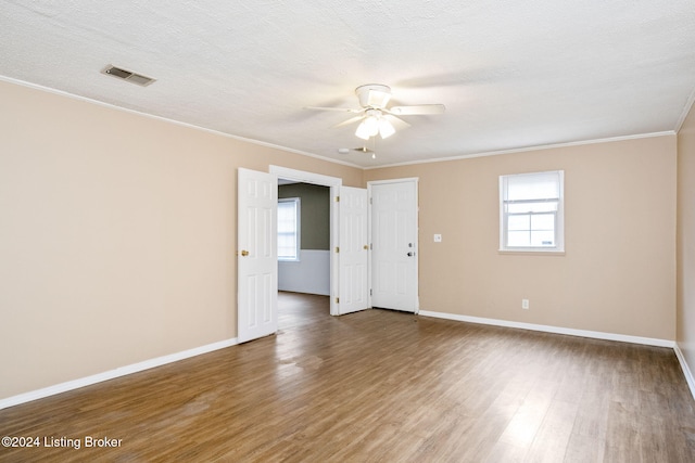 spare room featuring crown molding, hardwood / wood-style floors, ceiling fan, and a textured ceiling