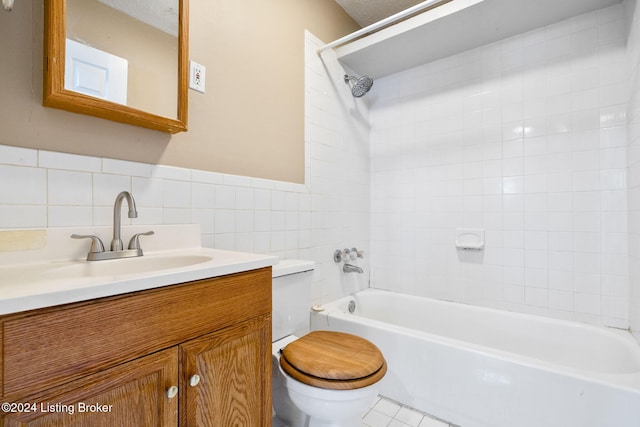 full bathroom with vanity, a textured ceiling, toilet, and tiled shower / bath