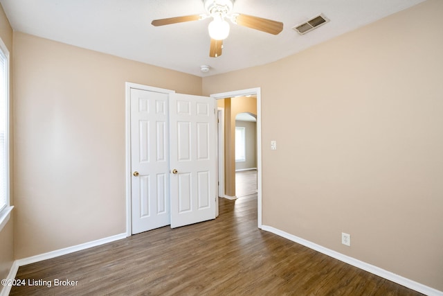 unfurnished bedroom featuring ceiling fan, dark hardwood / wood-style flooring, and a closet