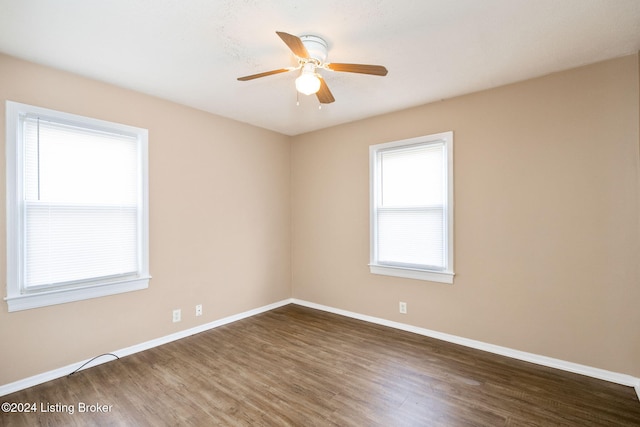 spare room with dark hardwood / wood-style flooring and ceiling fan