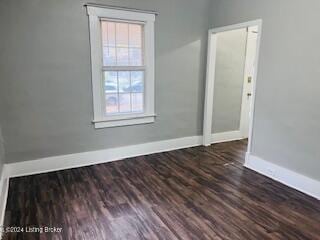 spare room with dark wood-type flooring