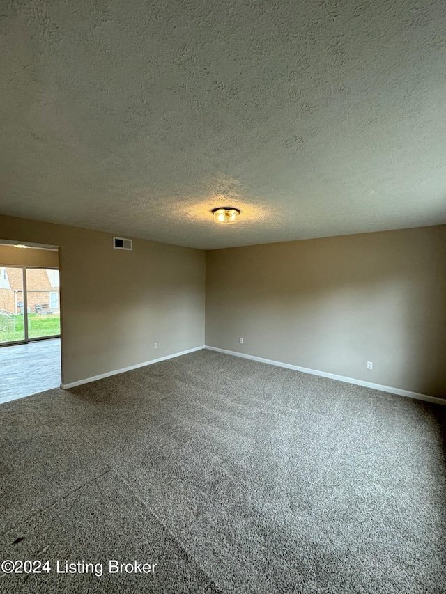 carpeted spare room with a textured ceiling