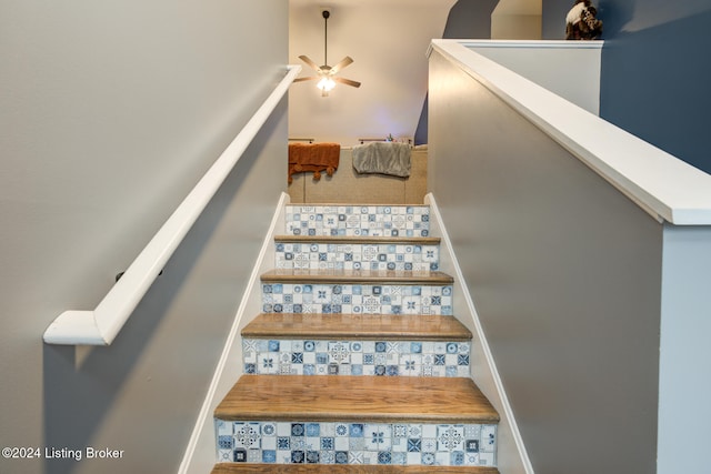 stairs featuring ceiling fan