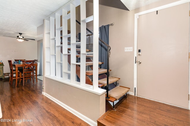 stairs with hardwood / wood-style floors, ceiling fan, and a textured ceiling