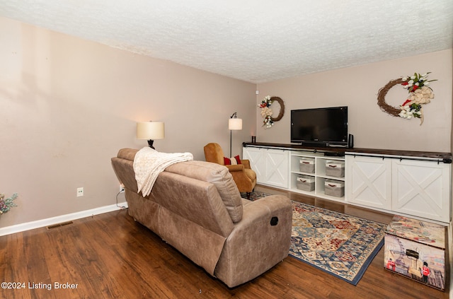 living room with wood-type flooring and a textured ceiling